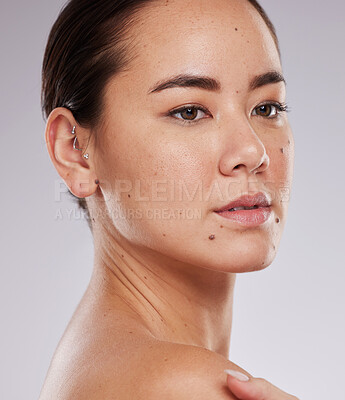 Buy stock photo Beauty, skincare and face of a woman in studio dermatology and cosmetics for skin glow. Aesthetic asian model person with makeup shine, mole and facial self care for wellness on grey background