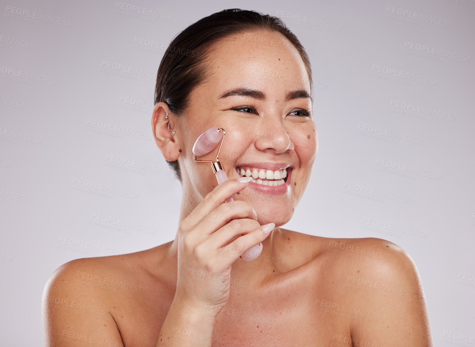 Buy stock photo Face skincare, beauty and Asian woman with jade roller in studio isolated on gray background. Dermatology aesthetics, thinking or happy female model with rose quartz stone or crystal for skin health.