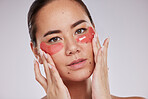 Face portrait, skincare and woman with eye patches in studio isolated on a gray background. Dermatology, cosmetics and young female model with facial pads or products for skin treatment and beauty.