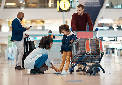 Buy stock photo Mother tie shoes of girl at airport for travel, family holiday and vacation with luggage, suitcase and trolley. International journey, transport and mom, girl and dad waiting for flight departure