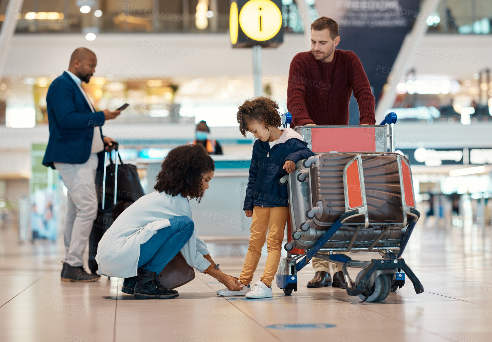 Buy stock photo Mother tie shoes of girl at airport for travel, family holiday and vacation with luggage, suitcase and trolley. International journey, transport and mom, girl and dad waiting for flight departure