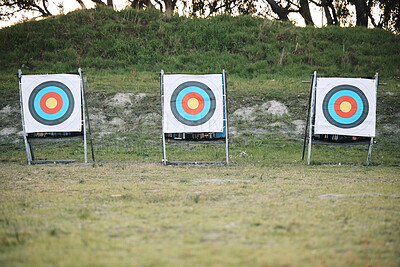 Buy stock photo Bullseye target board, outdoor and field at shooting range for weapon training, aim and accuracy. Sports, archery and poster for gun, bow and arrow at academy for police, army or security in nature