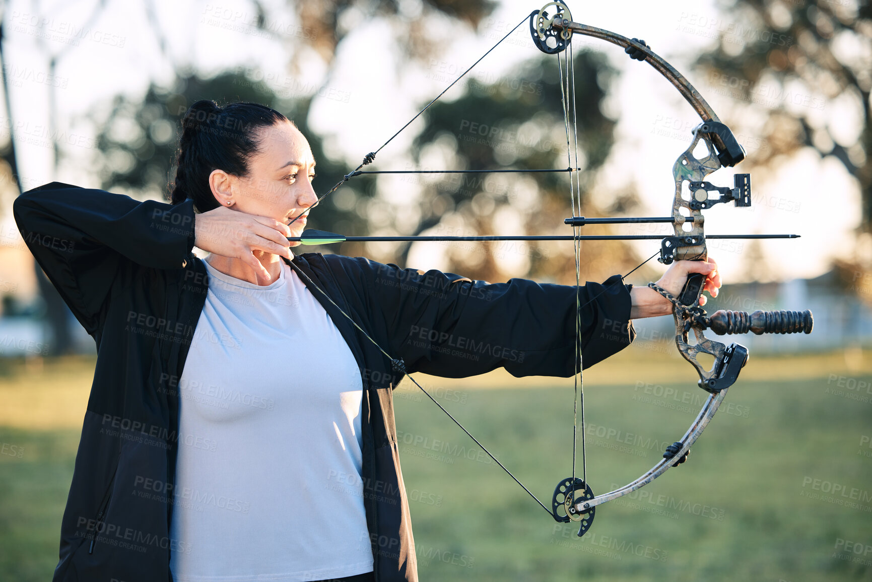 Buy stock photo Hobby, learning and woman playing archery as a sport, outdoor activity and game in nature of France. Training, practice and girl with a bow and arrow for sports, competition and shooting at a park