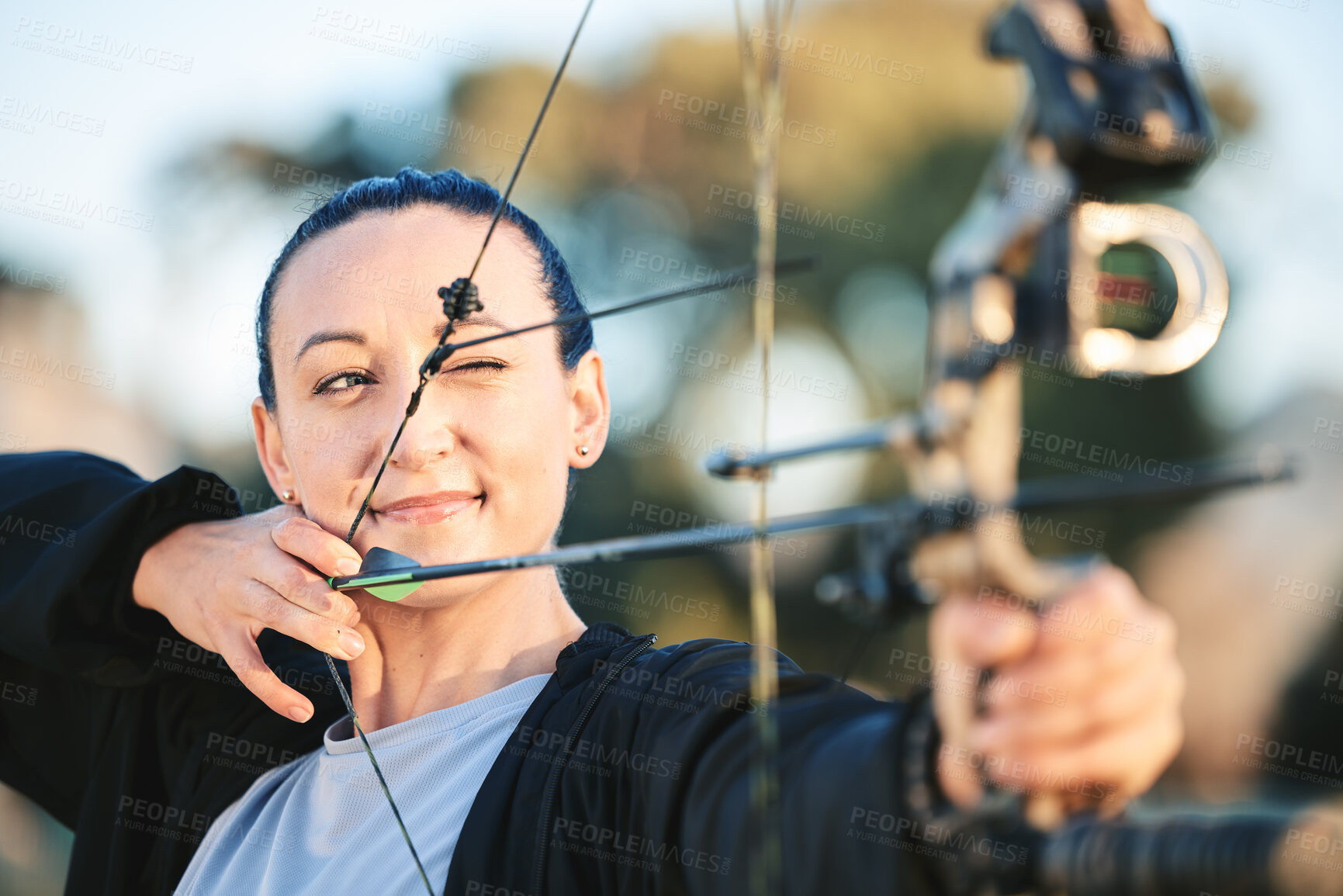 Buy stock photo Archery bow, woman aim and shooting range for competition, game or practice at an outdoor sports or park.  Hunter or person face with arrow for gaming, adventure and hunting with focus on target