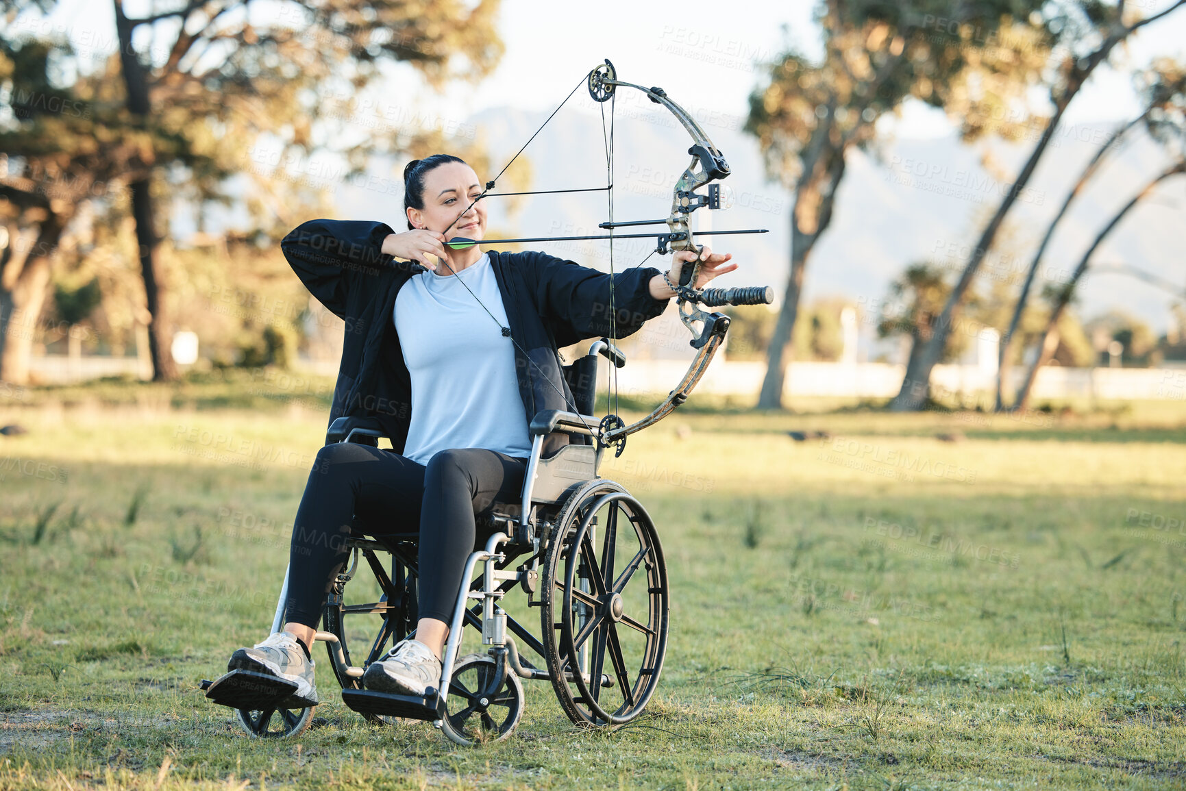 Buy stock photo Disabled woman, outdoor archery in wheelchair and challenge with active sports lifestyle in Canada. Person with disability in a park, fitness activity to exercise arms and aim arrow for hobby