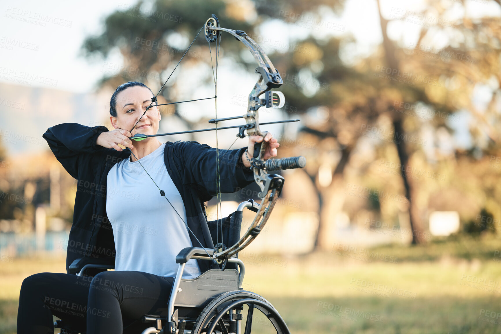 Buy stock photo Disabled sports woman, outdoor archery in wheelchair and challenge with active lifestyle in Canada. Person with disability in a park, fitness activity to exercise arms and aim arrow for hobby