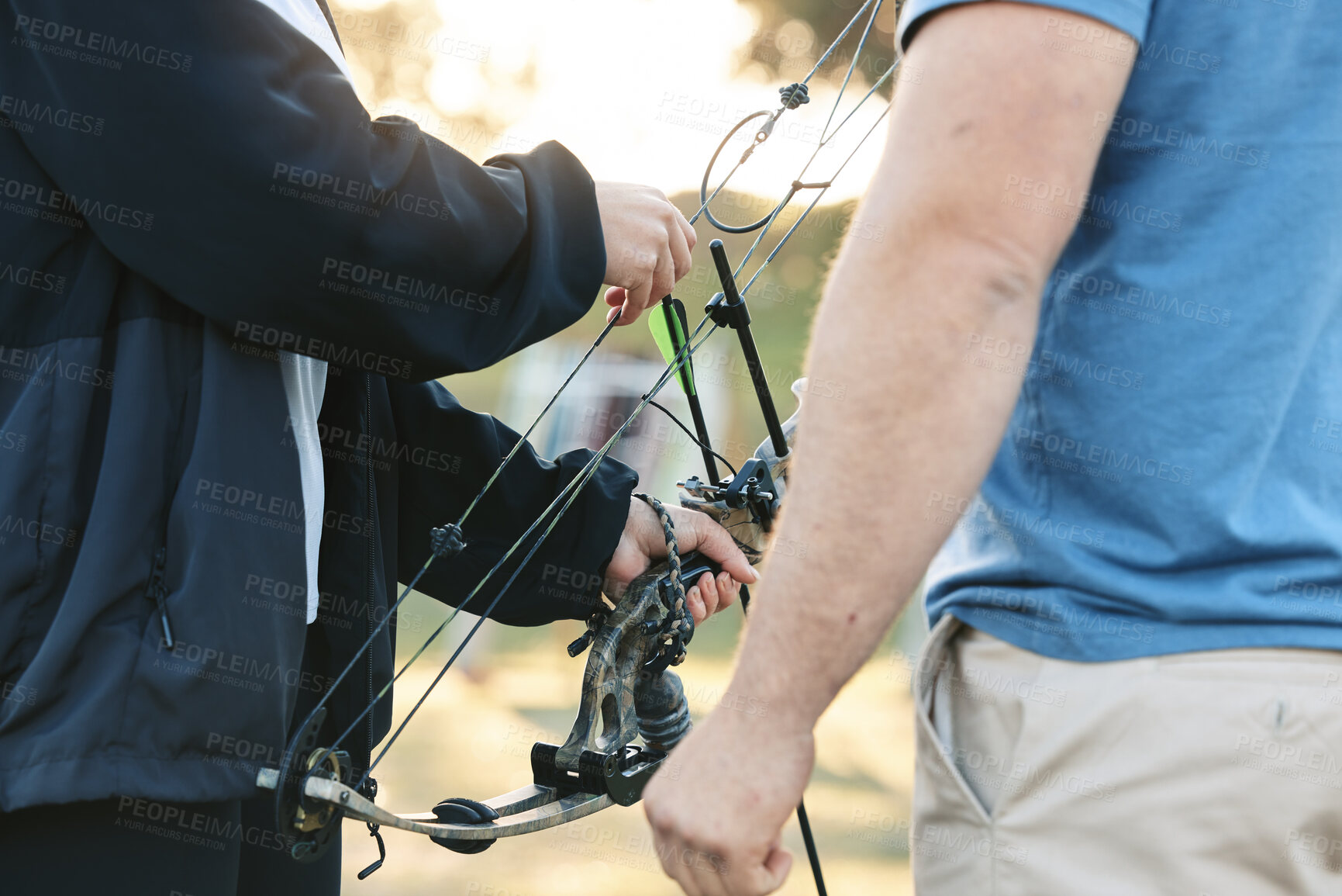 Buy stock photo Shooting range, bow and archery sports training with a woman and man outdoor for target practice. Hands of archer and athlete person for competition game or learning to aim, exercise and shoot arrow 