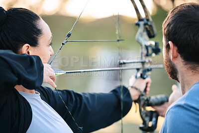 Buy stock photo Archery, woman and target training with an instructor on a field for hobby, aim and control. Arrow, practice and archer people together outdoor for hunting, precision and weapon, shooting competition