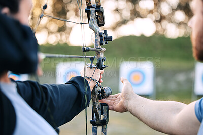 Buy stock photo Archer hands, coach and bow or arrow learning for archery competition, athlete focus challenge or girl training practice. Teacher, teaching and man coaching woman on sports, aim and target shooting