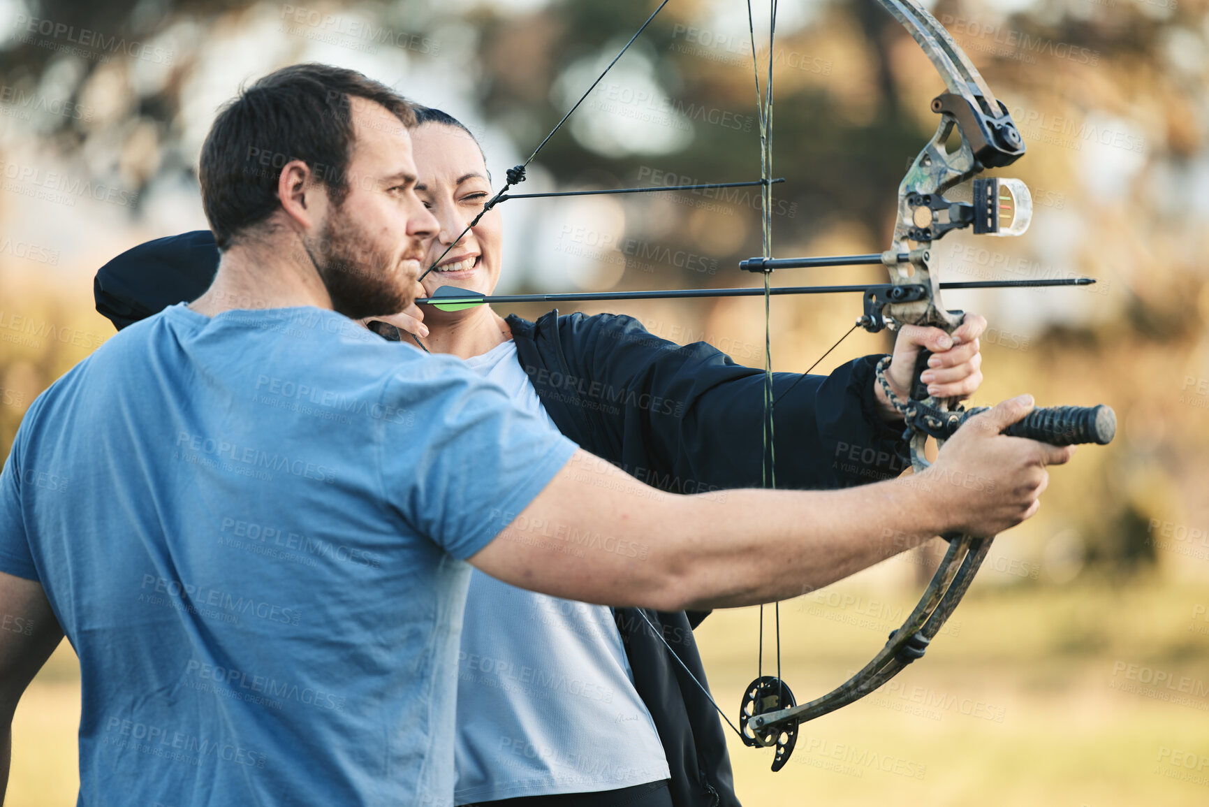 Buy stock photo Archery, bow and shooting range sports training with a woman and man outdoor for target practice. Archer and athlete person with focus on field for competition or game to aim arrow for action
