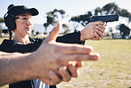 Man, woman and gun training with aim, outdoor target or hand position at police, army or security academy. Shooting coach, pistol or firearm for sport, safety or combat exercise in nature for vision