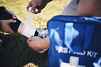First aid, hands and man medic with ankle sports injury at field for running, training or marathon practice. Medical, closeup and emergency service for runner person with injured foot during workout
