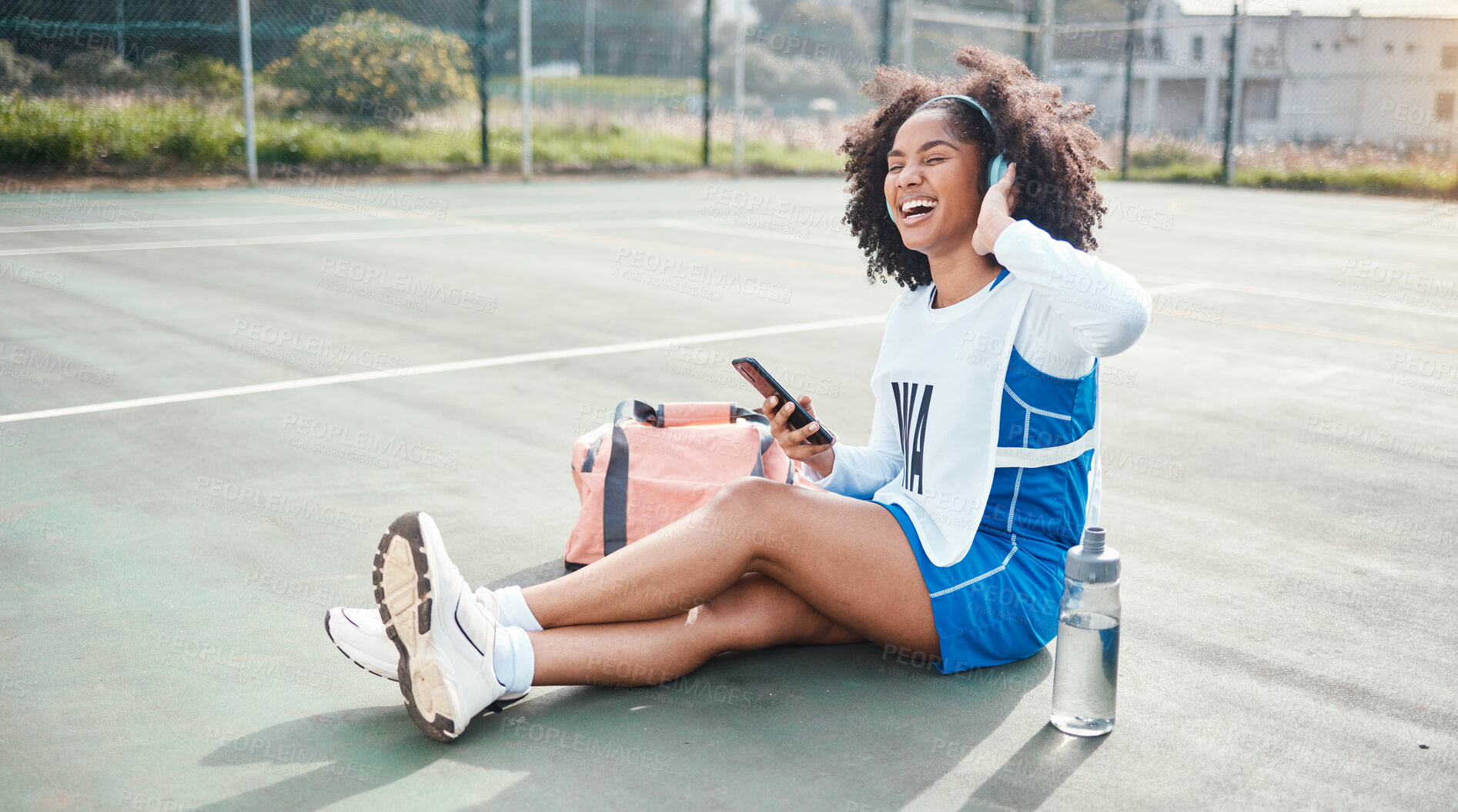 Buy stock photo Sports music, phone and netball woman listening to mp3 radio, audio podcast or playlist song after training practice. Relax wellness, digital headphones and African athlete streaming sound on court