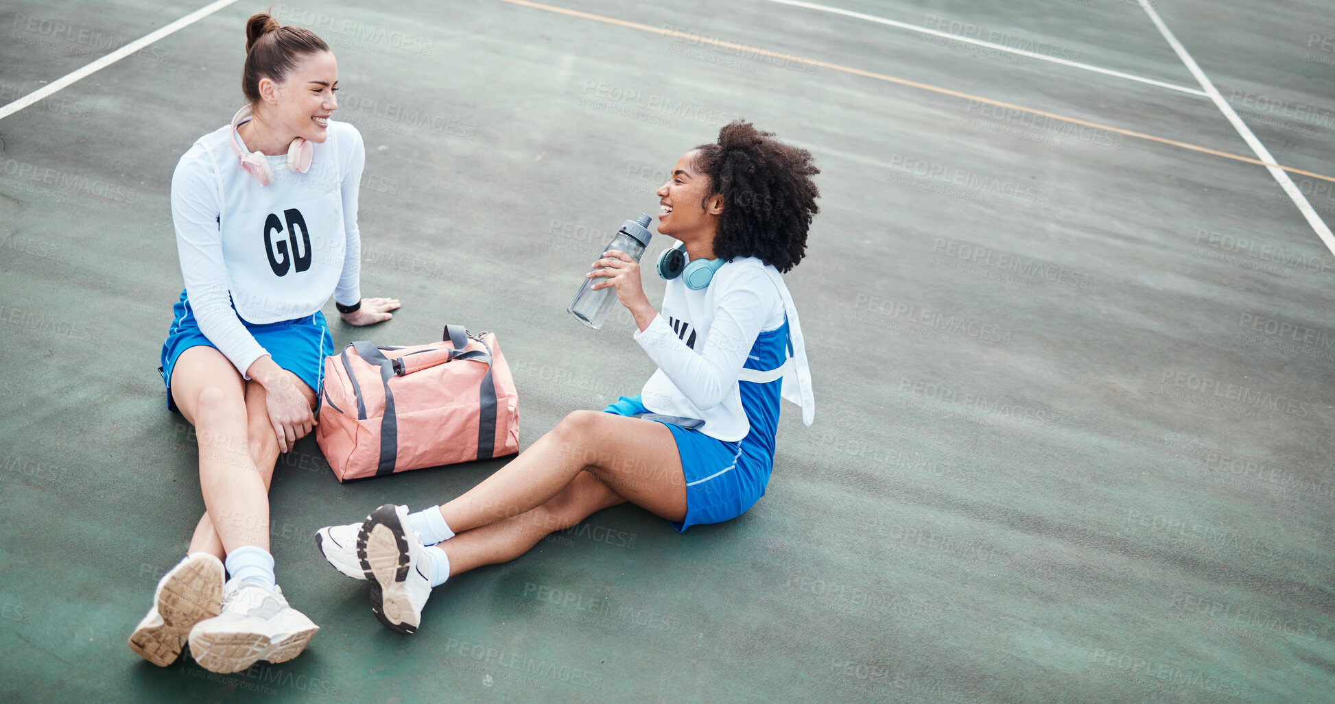 Buy stock photo Netball, friendship and girls talking outdoor after a match, training or exercise on the court. Happy, friends and female athletes laughing, speaking and bonding together after a game or practice.
