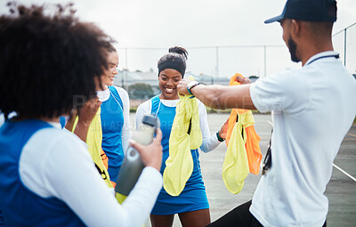 Buy stock photo Coach, vest or team in netball training game, workout or exercise for a match on sports court. Teamwork, fitness group or manager giving bibs to excited athlete girls with happy smile in practice