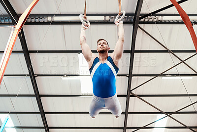 Buy stock photo Man, acrobat and gymnastics swinging on rings in fitness for practice, training or workout at gym. Professional male gymnast hanging on ring circles for athletics, acrobatics or strength exercise