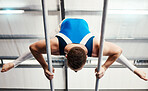 Gymnastics man, bars and training with balance, strong body and focus for sports, vision and professional career. Gymnast, athlete and exercise with muscle development, workout and low angle at gym