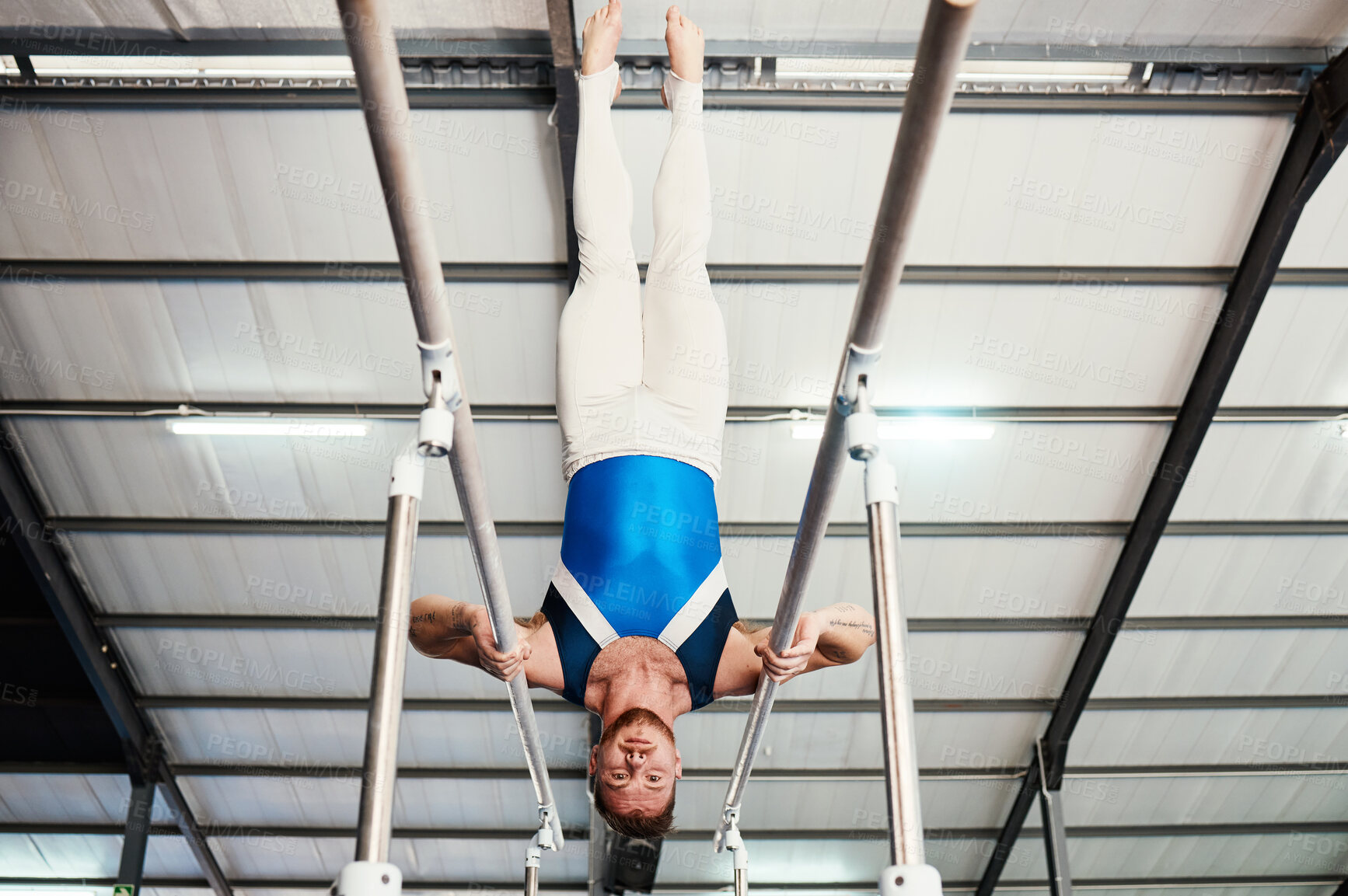 Buy stock photo Man, gymnast and upside down on poles in fitness for practice, training or workout at gym. Professional male acrobat in gymnastics holding body weight up on rail for athletics or strength exercise