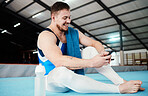 Man, gymnast and phone with smile for social media, chatting or texting sitting on floor at the gym. Happy male acrobat in fitness smiling for chat, text or communication on smartphone after workout