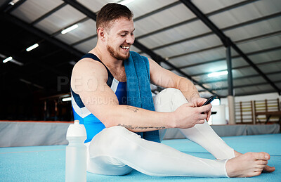Buy stock photo Man, gymnast and phone with smile for social media, chatting or texting sitting on floor at the gym. Happy male acrobat in fitness smiling for chat, text or communication on smartphone after workout