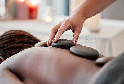 Buy stock photo Hot stone massage, spa and hand of masseuse, holistic care and wellness with black woman and treatment. Health, peace of mind and self care with zen, stress relief for people and back skin detox