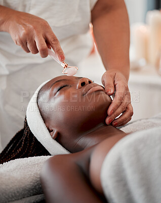 Buy stock photo Black woman, face roller and luxury spa treatment of a young female ready for facial. Skincare, rose quartz tool and wellness clinic with client feeling calm and zen from massage and dermatology