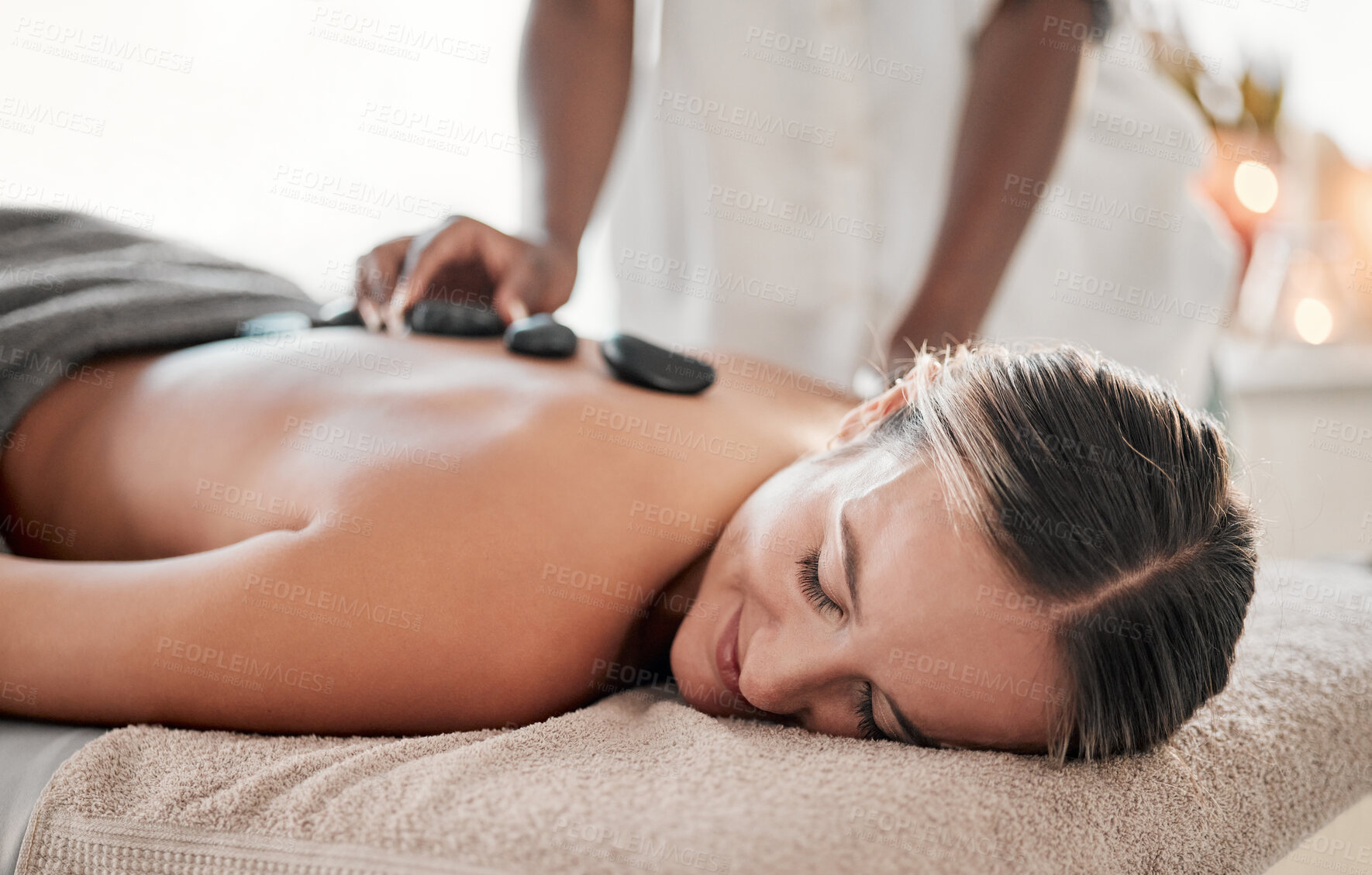 Buy stock photo Woman, hot stones or back massage in spa to relax for zen, meditation or wellness physical therapy treatment in resort. Beauty, salon or happy female for luxury healthcare, rock or spiritual peace 