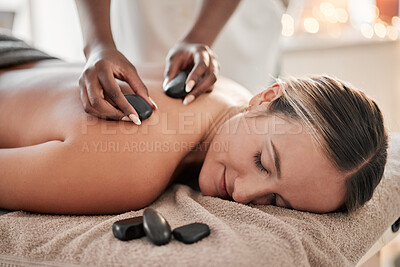 Buy stock photo Woman, hot stone massage and therapist, hands and zen with holistic therapy and spa treatment for back. Calm, peace of mind and face, healing and stress relief with self care at wellness resort 
