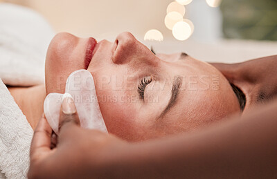 Gua sha, skincare and woman getting a face massage for wellness, health and self care at a spa. Beauty, cosmetic and calm young female doing a luxury facial treatment with rose quartz at a zen salon.