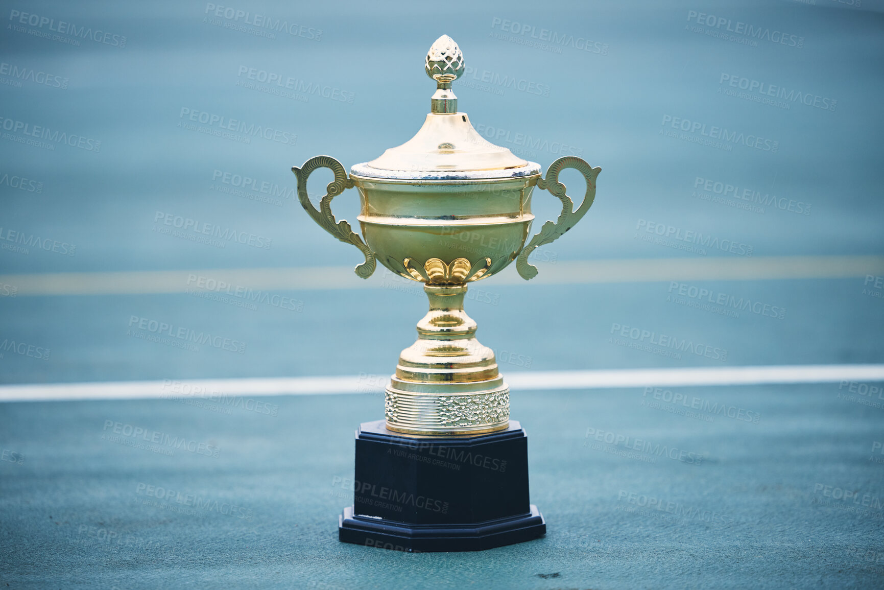 Buy stock photo Trophy, award and target with a sports cup on an empty court outdoor for the winner, champion or victor. Gold, goal and success with a prize on the floor outside at a stadium or arena for sport