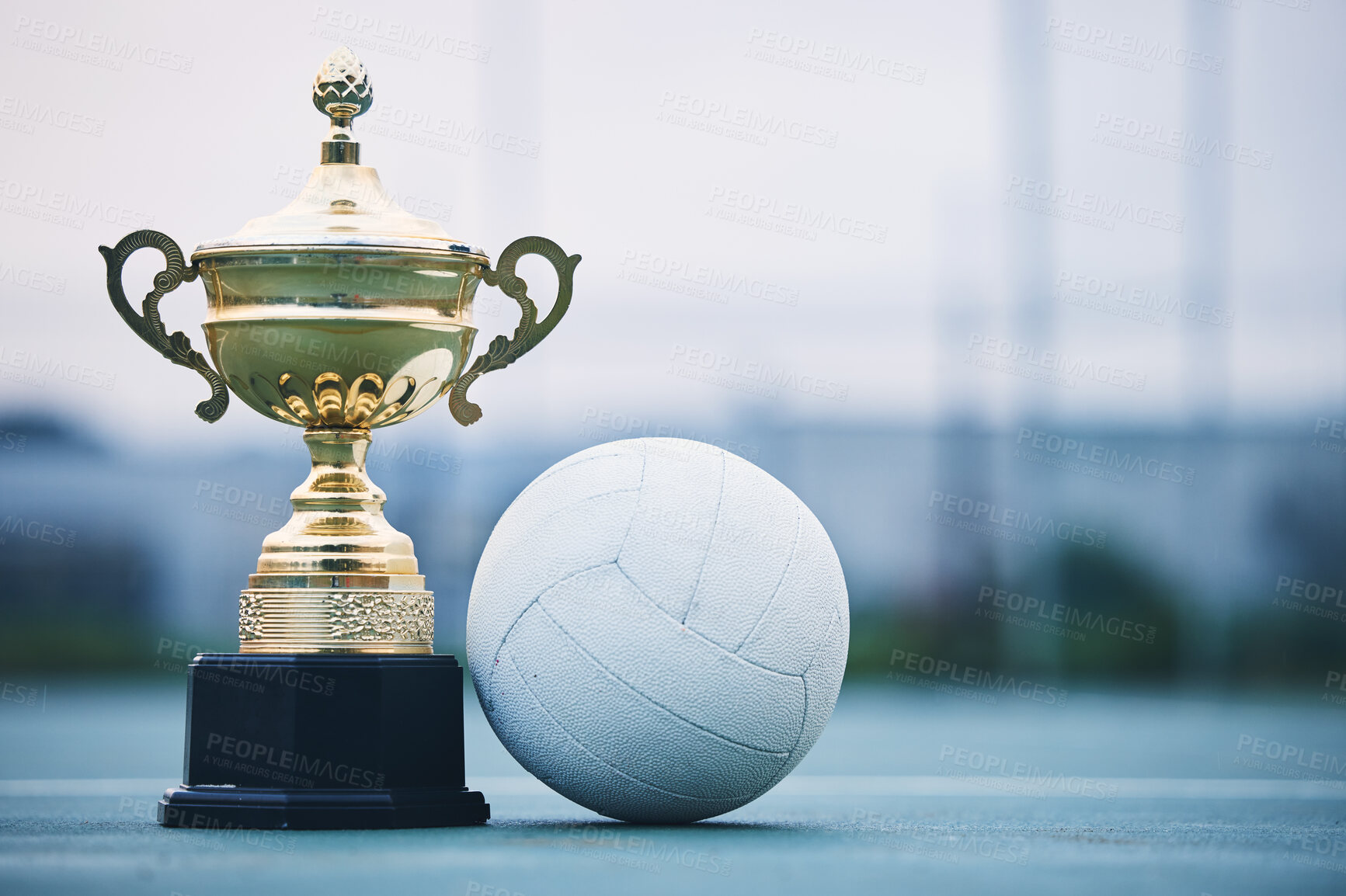 Buy stock photo Gold, winner and sports with trophy and netball for achievement, award and championship. Celebration, fitness and victory with prize and ball on ground of court for event, competition and success