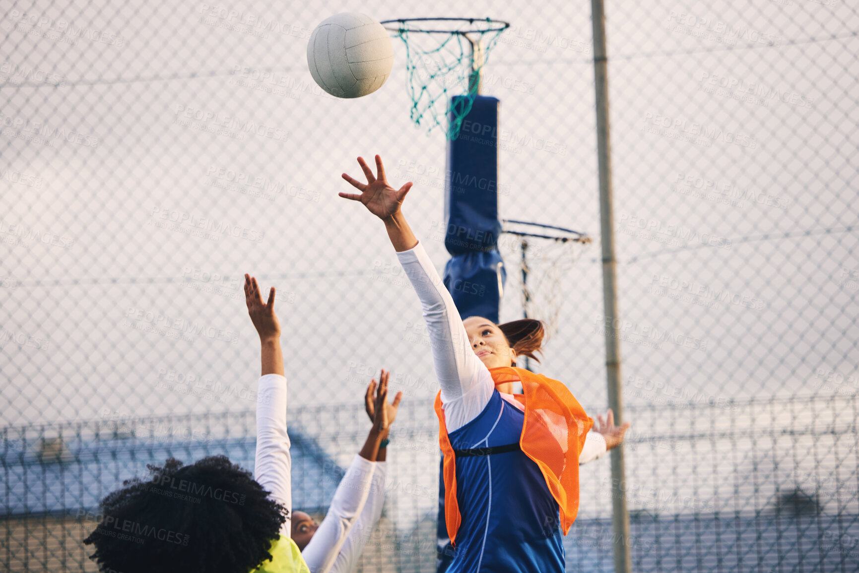 Buy stock photo Netball, goal shooting and defense of a girl athlete group on an outdoor sports court. Aim, sport game and match challenge of a black person with a ball doing exercise and training in a competition