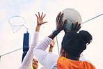 Netball, goal shooter and fitness of a girl athlete group on an outdoor sports court. Aim, sport game and match challenge of a black person with a ball doing exercise and training in a competition