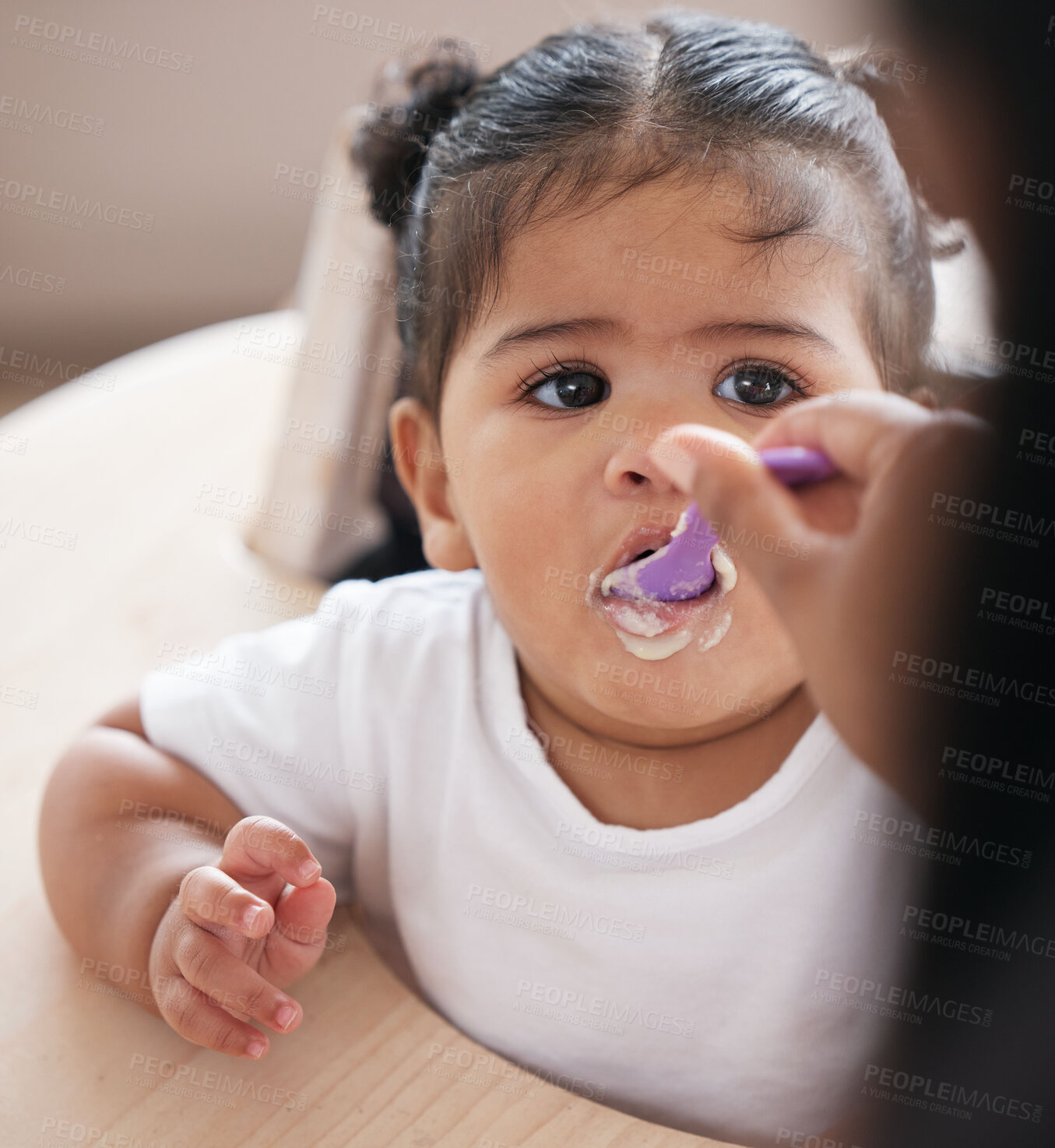 Buy stock photo Baby, food and hand feeding with spoon while eating for nutrition, development and growth in a chair. Face of girl toddler or child having breakfast, lunch or dinner while hungry in family home