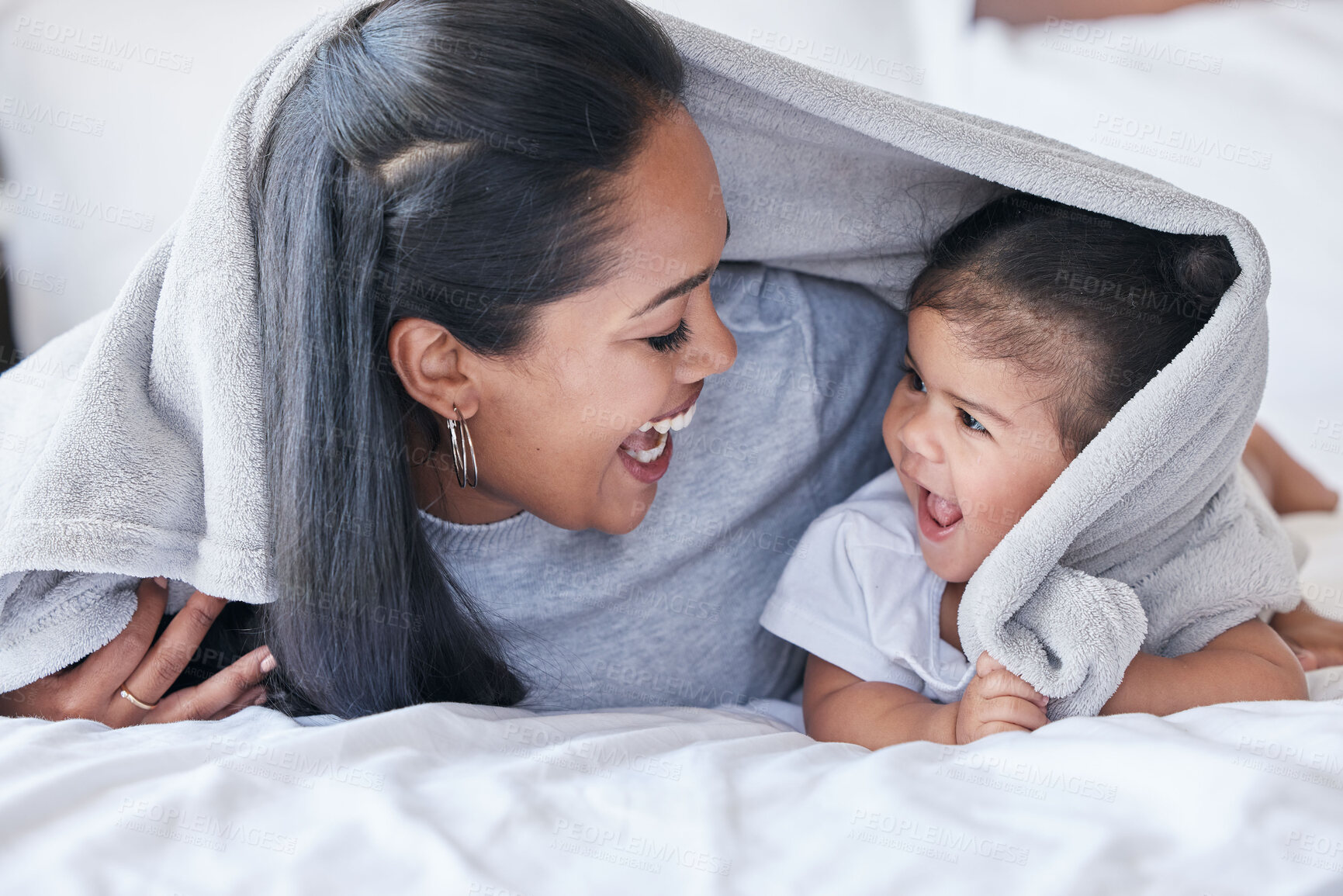 Buy stock photo Mother, parent and baby playing or bonding in a bed with blanket laughing being funny together in a bedroom or room. Mom, kid and single mum in a home or house with little daughter or child