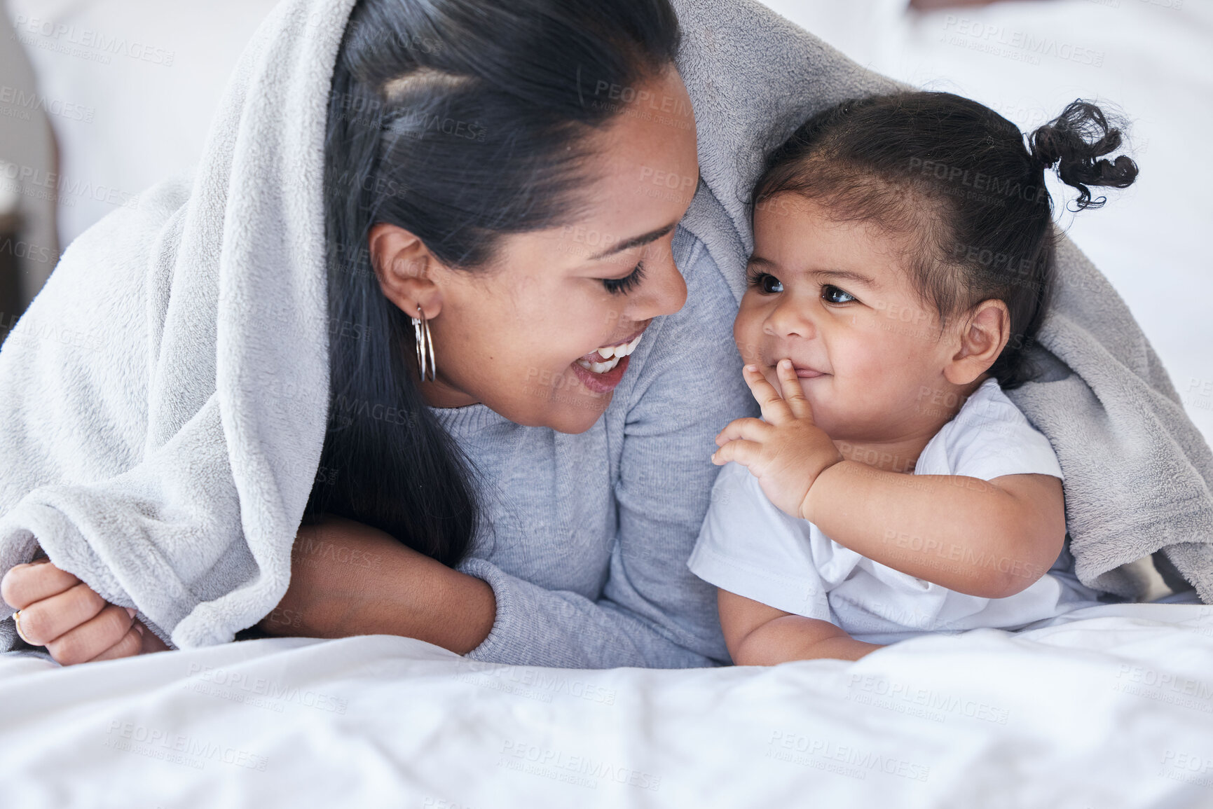 Buy stock photo Mother, child and baby playing with woman bonding in a bed with blanket laughing being funny together in a bedroom or room. Mom, kid and single parent in a home or house with little daughter