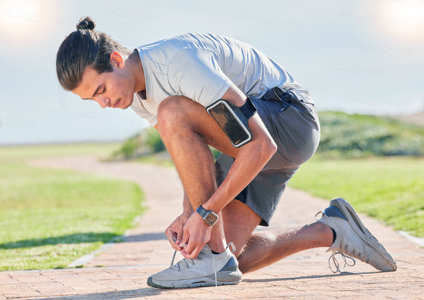 Buy stock photo Shoes, fitness man and runner tying laces for running, exercise and training outdoor. Sports, pavement and park run of a athlete doing wellness and health sport for marathon or race in summer