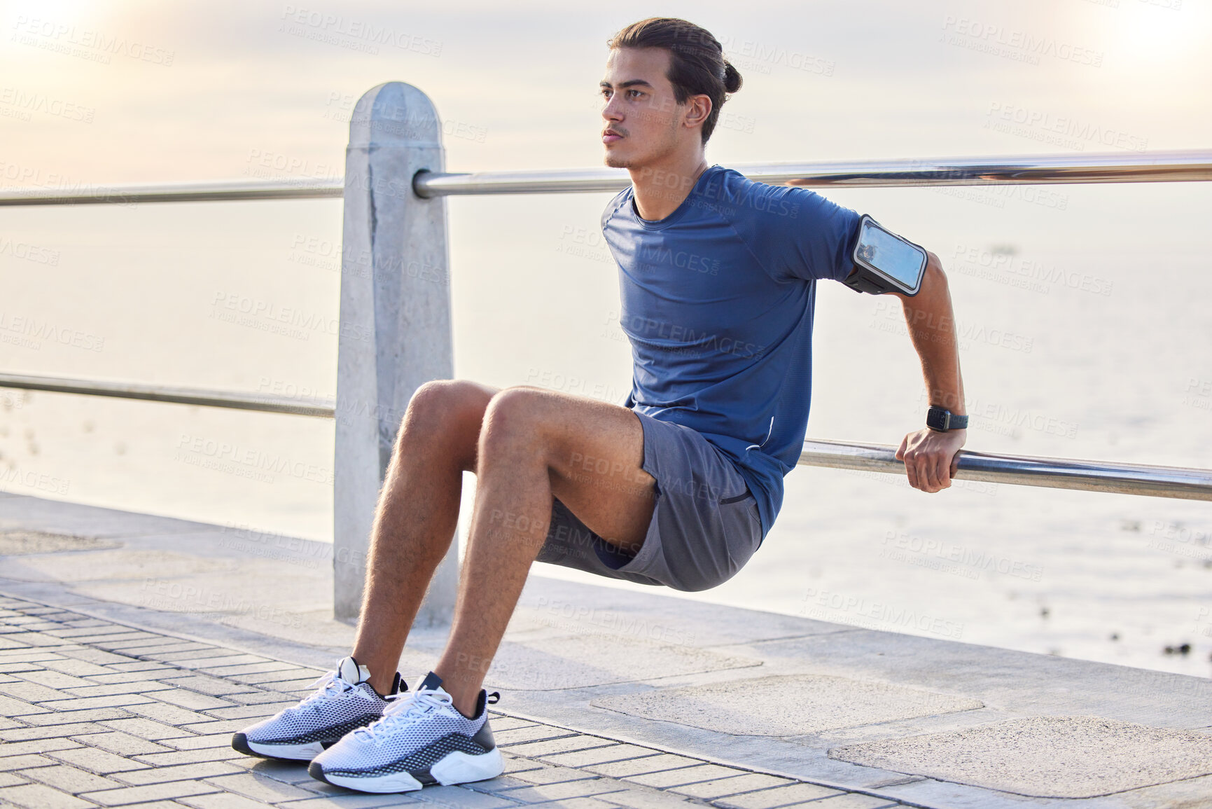 Buy stock photo Fitness, stretching and man at a beach for training, exercise and running at sunset, serious and focus. Mindset, stretch and workout for mexican guy at ocean, competitive and concentration before run