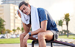 Fitness, exercise and tired man with a towel on park bench to relax or rest after running for cardio. Sports person with fatigue and sweating outdoor post workout or training for health and wellness