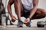 Hands, fitness and tie shoes in gym to start workout, training or exercise practice. Sports, health and black man or athlete tying sneakers to get ready for exercising, running or cardio for wellness