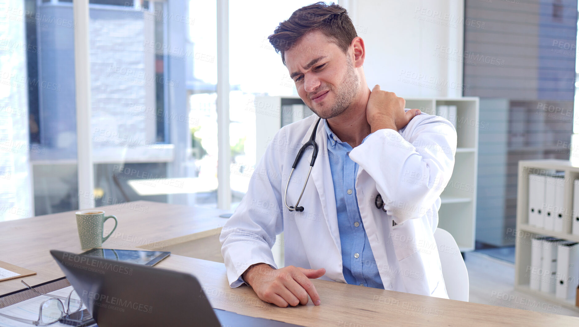 Buy stock photo Man, doctor and laptop with neck pain, ache or tension sitting by office desk in stress or discomfort at hospital. Healthcare male suffering holding painful area from work injury, bruise or sore