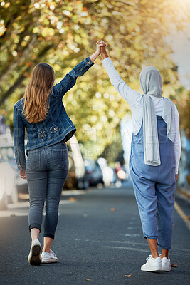 Buy stock photo Support, solidarity and lesbian couple holding hands in the street for walking, trust and love. Equality, freedom and back of a Muslim woman with a girl showing affection in lgbt relationship