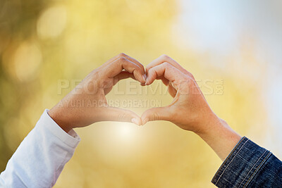 Buy stock photo Closeup, hands and heart for support, solidarity and community with light, collaboration and commitment. Zoom, couple and sign for love, sunlight and peace with care, romantic and emoji for bonding