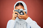Photography, muslim woman taking picture with camera and mockup with smile isolated on red background. Creative professional lifestyle photographer in hijab, hobby or career taking photo in studio.