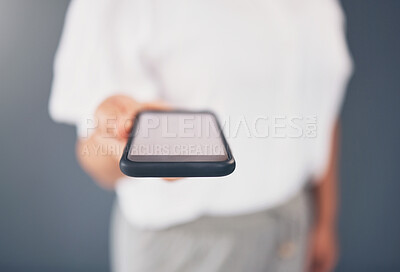 Buy stock photo Mockup, showing and hand of a woman with a phone screen isolated on a grey studio background. Contact, networking and employee giving a mobile for communication, call or message on a backdrop