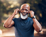 Black man, listening to music and smile for fitness and exercise outdoor in nature for cardio. Happy senior person with earphones for podcast during training or workout for body health and wellness