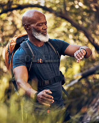 Buy stock photo Hiking, man and watch on adventure in nature forest for trekking, fitness and cardio exercise. Senior black person with backpack while walking outdoor in woods for travel, health and wellness