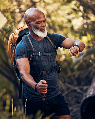 Buy stock photo Man, hiking and watch on adventure in nature for trekking, fitness and cardio exercise. Senior black person with backpack walking outdoor with clock for gps travel time, health and wellness app