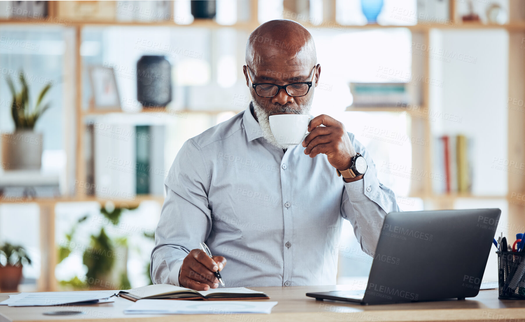 Buy stock photo Business, black man and drinking coffee while writing in notebook, schedule and strategy at office desk. Mature entrepreneur planning notes, information and journal of planner, agenda and reminder 