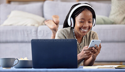 Buy stock photo Black woman, student and phone by laptop with smile for social media, elearning or communication in living room at home. Happy African American female with headphones on smartphone lying on floor